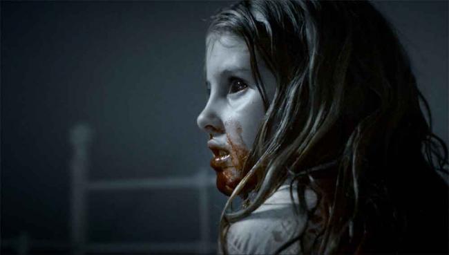 Szenenbild aus What We Become: kleines Mädchen mit schwarzen Augen und blutverschmiertem Mund