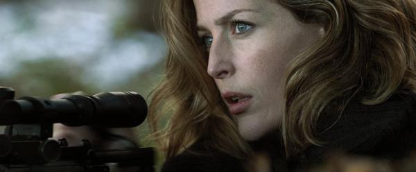 Gillian Anderson mit angelegtem Gewehr