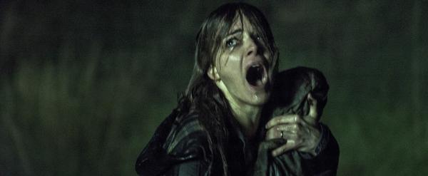 Schreiende Frau mit Baby in nächtlichem Regen