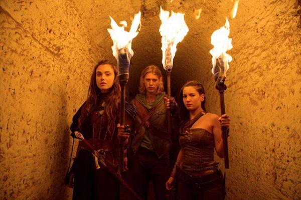 Shannara-Hauptcharaktere mit Fackeln in Katakomben